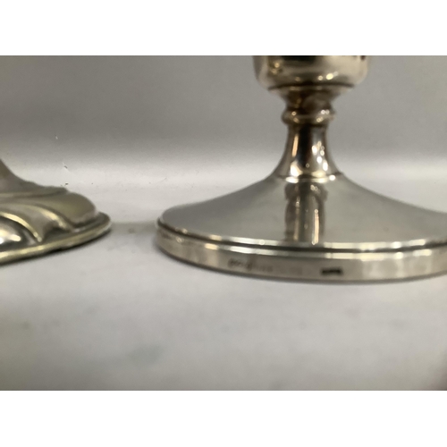 300 - A pair of silver short candlesticks, weighted bases, together with a silver plated candlestick with ... 