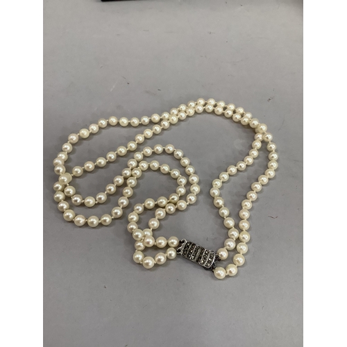 318 - A cultured pearl necklace approx 5.5mm size strung in two rows fastened with a silver marcasite set ... 