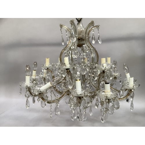 442 - An eighteen branch chandelier with glass drops and reeded arms