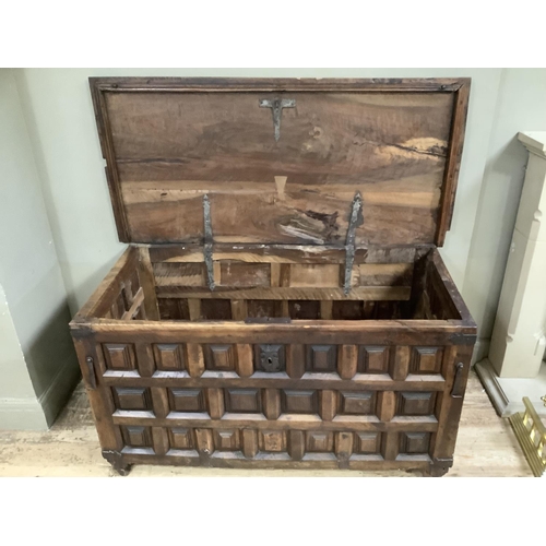 454 - A large continental fruitwood coffer with square panelling, iron bound on square legs