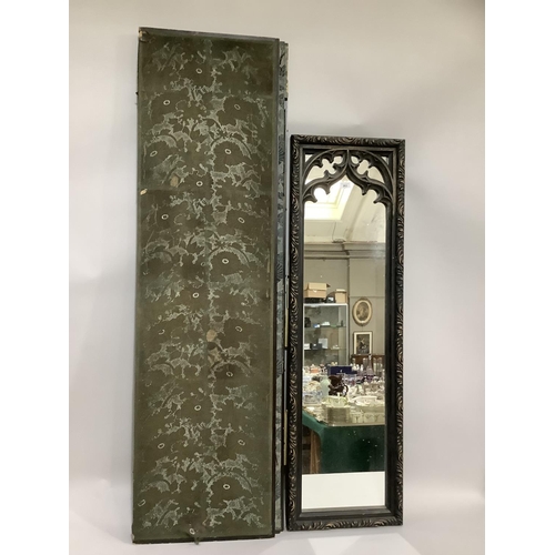 283 - A rectangular ebonised wall mirror of gothic tracery and foliate carved frame measuring 139cm x 41cm... 