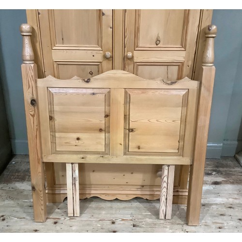 401 - A pine wardrobe having a moulded and dentil cornice above two indented panel doors with drawers belo... 