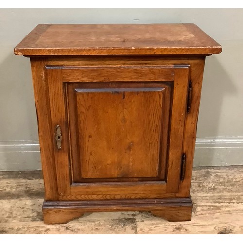 398 - An oak single door cupboard on bracket feet, 61cm wide, 32cm deep, 72cm high