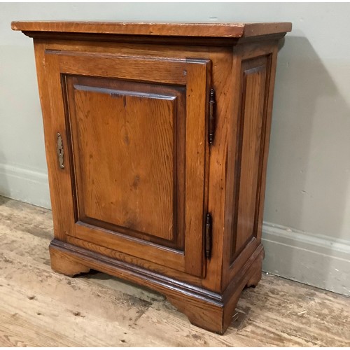 398 - An oak single door cupboard on bracket feet, 61cm wide, 32cm deep, 72cm high