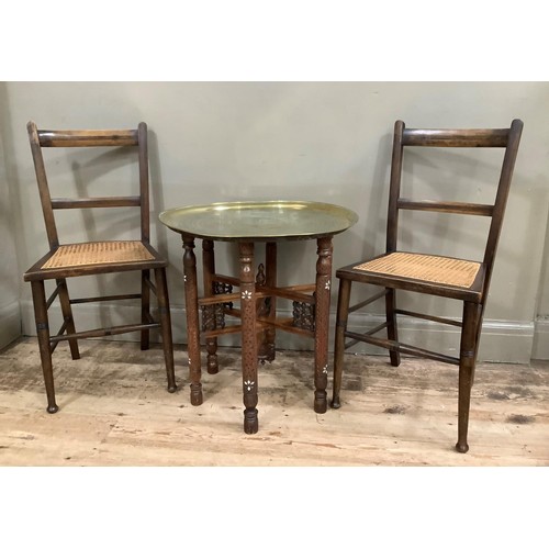 421 - A pair of caned bedroom chairs together with a Benares brass tray top with folding stand, diameter 5... 