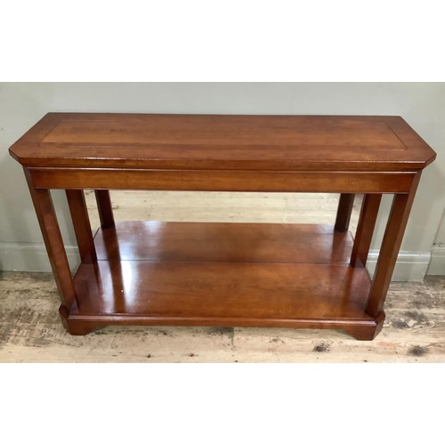 428 - A cherry wood console table, cherry wood with canted corners, lower mirrored back and under tier, on... 