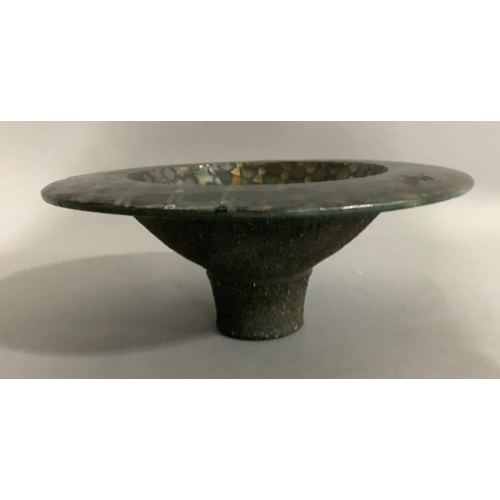 21 - An ceramic dish on a deep foot with wide rim, with metallic glaze, having geometric shapes in copper... 