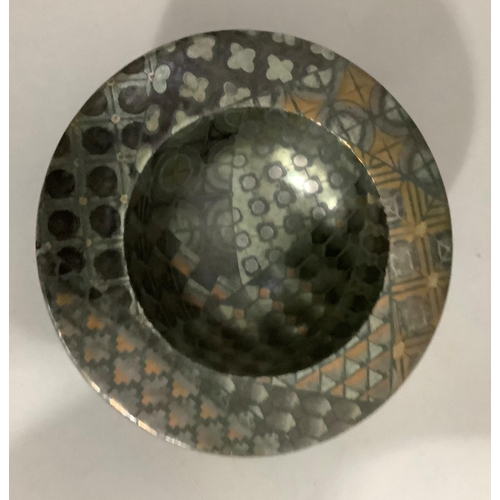 21 - An ceramic dish on a deep foot with wide rim, with metallic glaze, having geometric shapes in copper... 