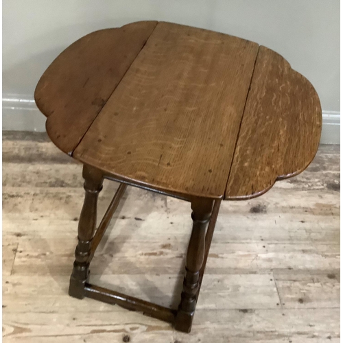 412 - An oak  drop leaf occasional table of oval outline on turned and square framing, 66cm deep x 66cm wi... 