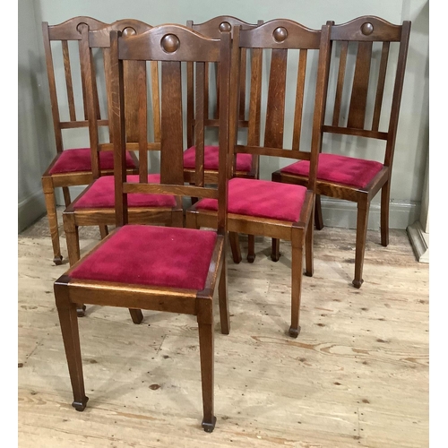 415 - A set of six 1920s oak dining chairs having a curved top rail and rail back, upholstered seat and on... 