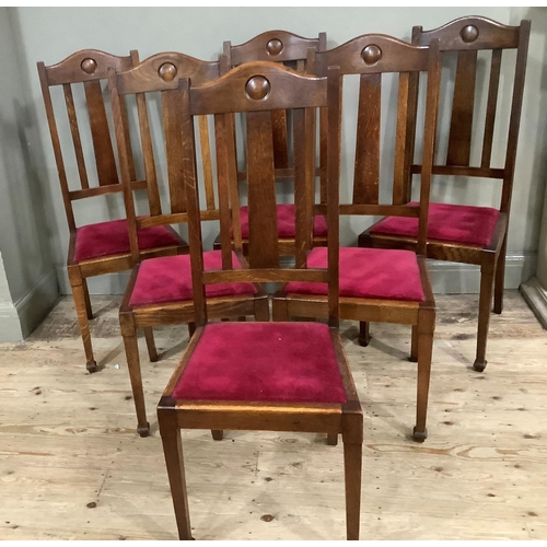 415 - A set of six 1920s oak dining chairs having a curved top rail and rail back, upholstered seat and on... 