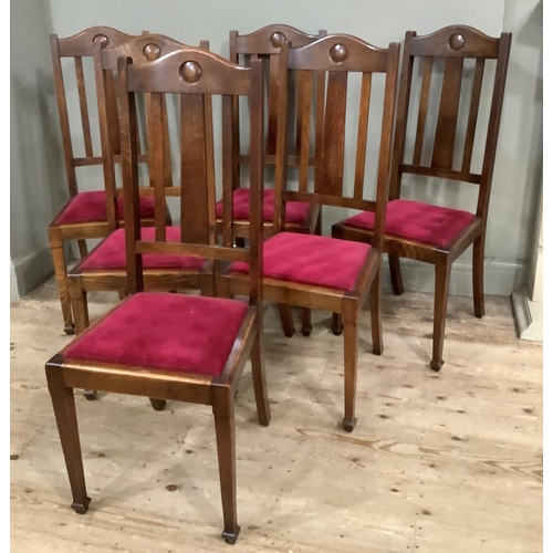 415 - A set of six 1920s oak dining chairs having a curved top rail and rail back, upholstered seat and on... 