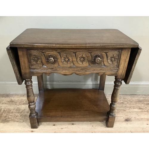 417 - An oak side table having a drawer to the frieze, twin drop leaves, on front turned legs joined by a ... 