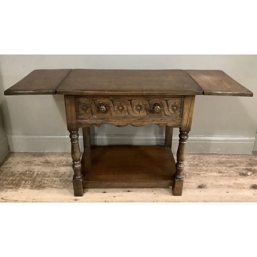 417 - An oak side table having a drawer to the frieze, twin drop leaves, on front turned legs joined by a ... 