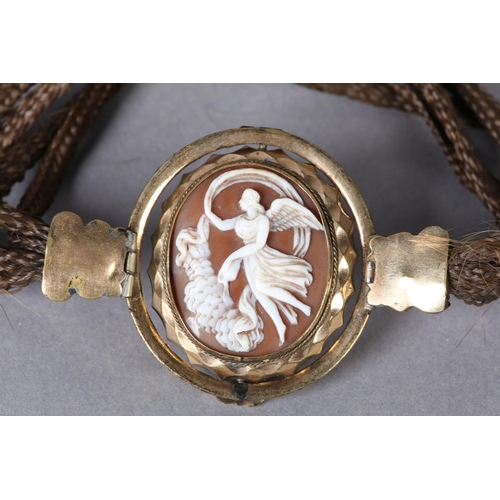 345 - A Victorian shell cameo set in rolled gold on a woven hair armlet, the oval portrait of Venus set wi... 