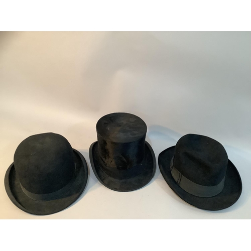 203 - A black bowler hat by Moores and another by G A Dunn, London together with a black top hat with feat... 