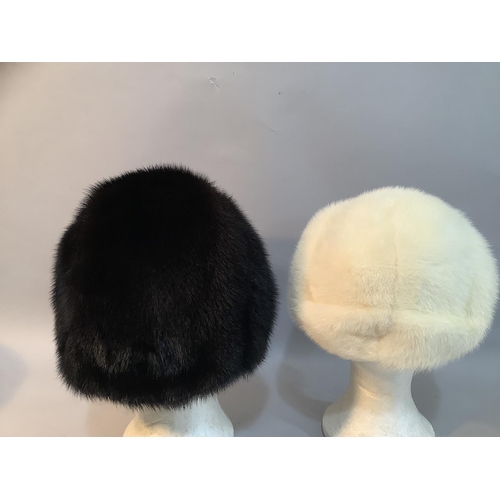 226 - Two Phillip Somerville winter hats,  in black-glama mink c.1977 and a white mink c.1979, both in hat... 