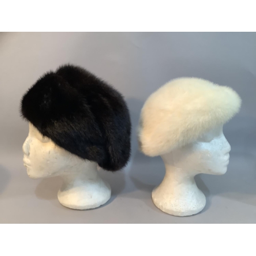 226 - Two Phillip Somerville winter hats,  in black-glama mink c.1977 and a white mink c.1979, both in hat... 