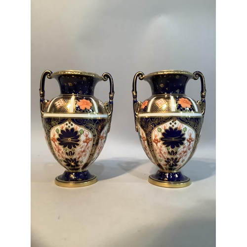 31 - A pair of early 20th century Royal Crown Derby Imari pattern  twin handled urns, 14cm high