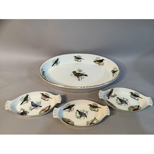 178 - A large Limoges serving dish painted with European birds together with three matching smaller dishes