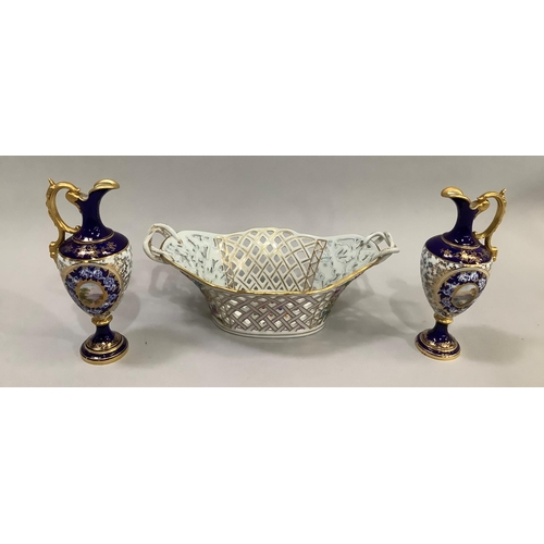 61 - A pair of late 19th century Coalport ewers, having cobalt blue ground with cartouches containing han... 