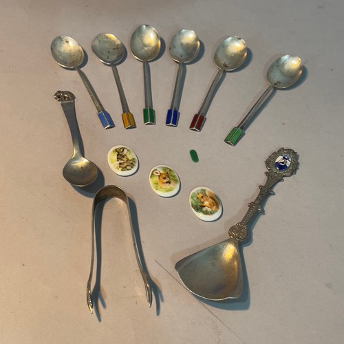 283 - A set of six silver and enamelled coffee spoons, a pair of silver sugar tongs, white metal souvenir ... 