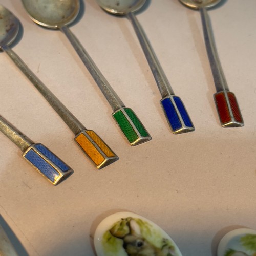 283 - A set of six silver and enamelled coffee spoons, a pair of silver sugar tongs, white metal souvenir ... 