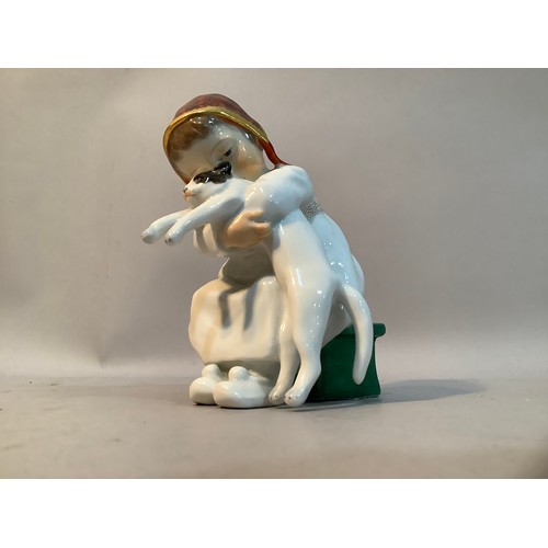 33 - A Meissen porcelain figure after Konrad Hentschel of a girl sat on green box with a cat in her arms,... 