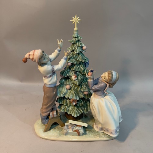 65 - A Lladro figure group 'Trimming the Tree' 34cm high