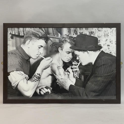 197 - Three black and white framed photographic prints showing people being tattooed, 60cm x 90cm