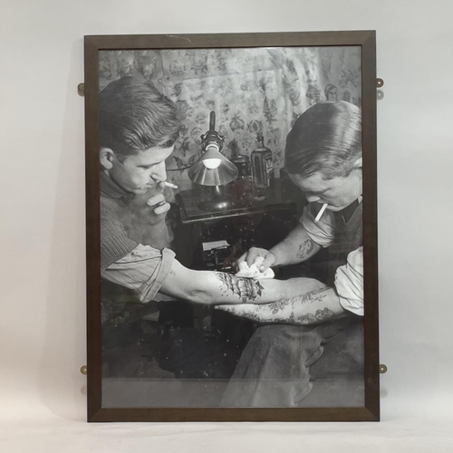 197 - Three black and white framed photographic prints showing people being tattooed, 60cm x 90cm