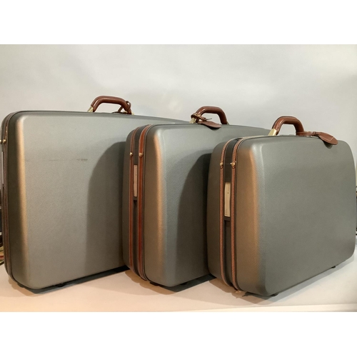 221 - Three Samsonite hard shell grey and leather suitcases with pull-along handles and wheels