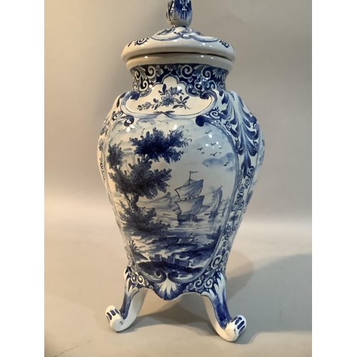 29 - A 20th Century Delft ware blue and white vase and domed cover with flower bud finial, the body paint... 