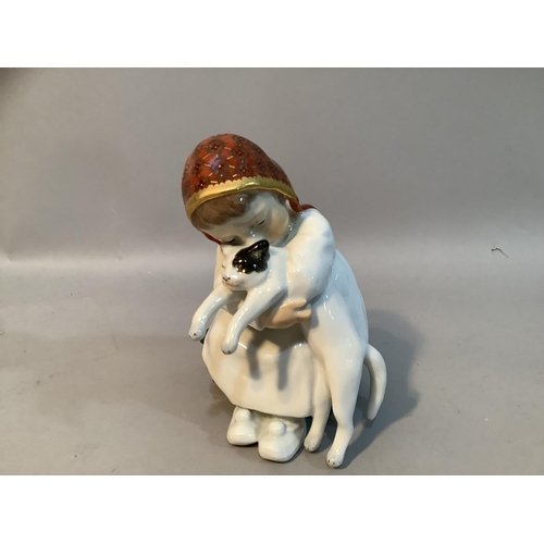 33 - A Meissen porcelain figure after Konrad Hentschel of a girl sat on green box with a cat in her arms,... 