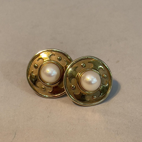 350 - A pair of cultured pearl ear studs in 9ct gold each set with a 7mm pearl raised against textured and... 