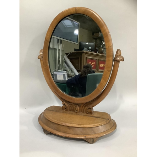 367 - A Victorian mahogany toilet mirror having an oval plate, the base with hinged lid