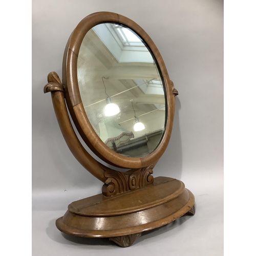 367 - A Victorian mahogany toilet mirror having an oval plate, the base with hinged lid