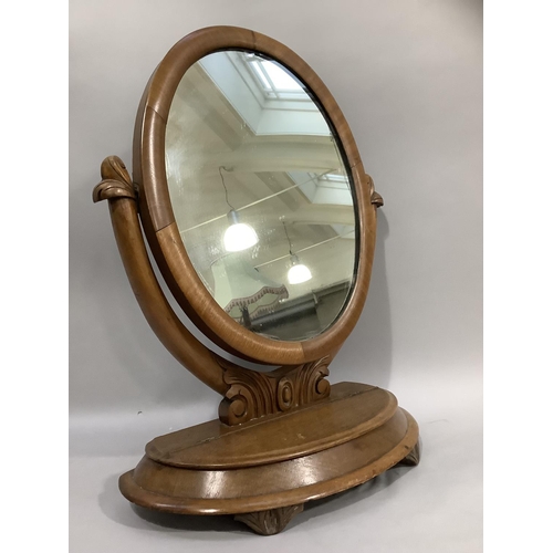 367 - A Victorian mahogany toilet mirror having an oval plate, the base with hinged lid