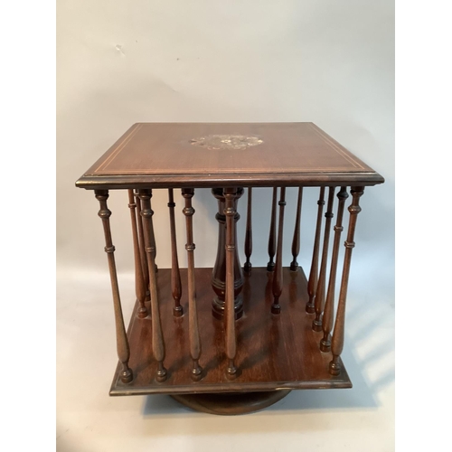 368 - An Edwardian mahogany table top revolving book stand of square outline with slender ring turned spin... 