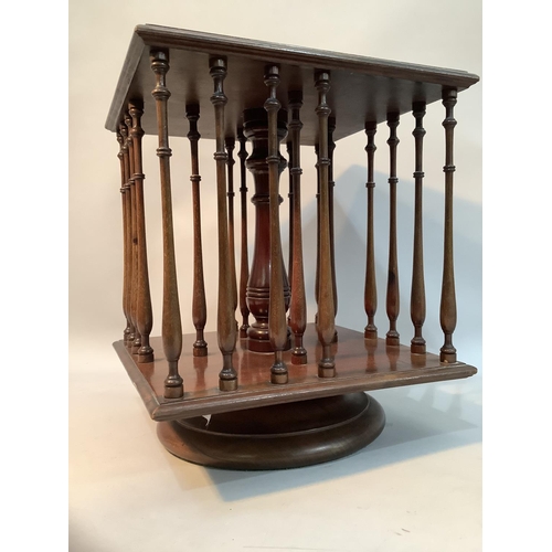 368 - An Edwardian mahogany table top revolving book stand of square outline with slender ring turned spin... 