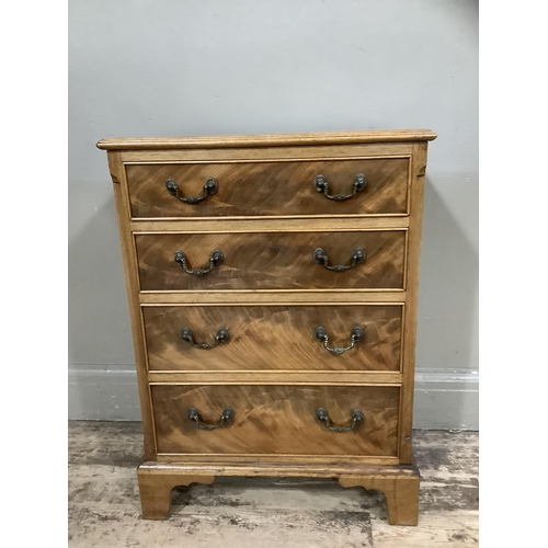 372 - A reproduction mahogany chest of four graduated drawers with swing handles and on shaped bracket fee... 