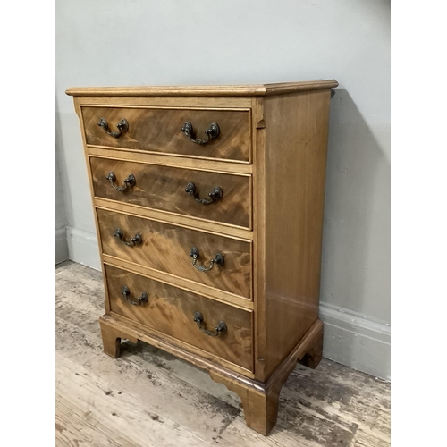 372 - A reproduction mahogany chest of four graduated drawers with swing handles and on shaped bracket fee... 