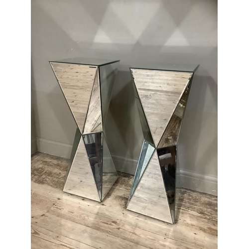 373 - A pair of mirrored plinth of square outline and waisted columns with angled panels, 33cm x 33cm x 96... 