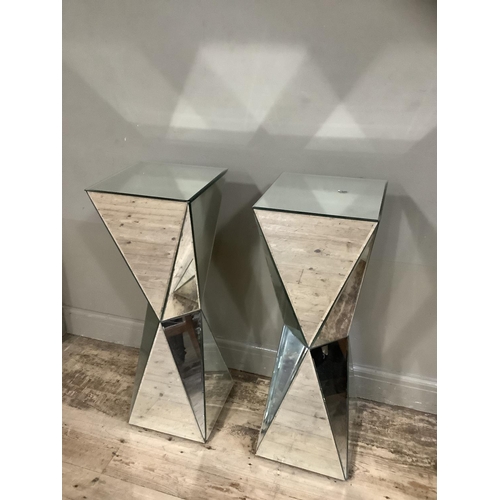 373 - A pair of mirrored plinth of square outline and waisted columns with angled panels, 33cm x 33cm x 96... 