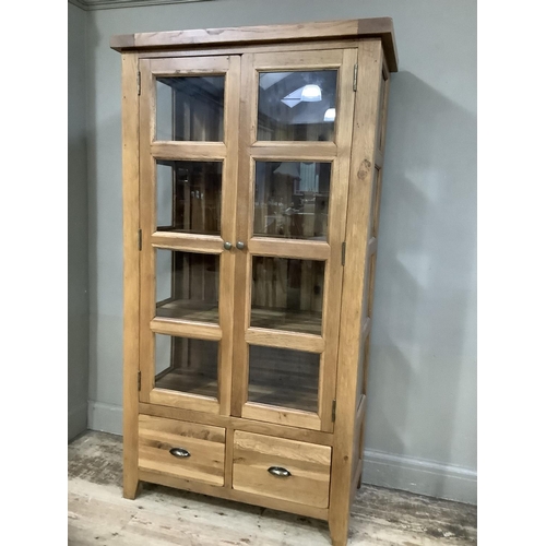 374 - A good quality oak and glazed display cabinet having a pair of eight panelled doors and conforming s... 