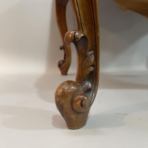 379 - A Victorian walnut stool, rectangular having the original floral needlework cover and on moulded cab... 