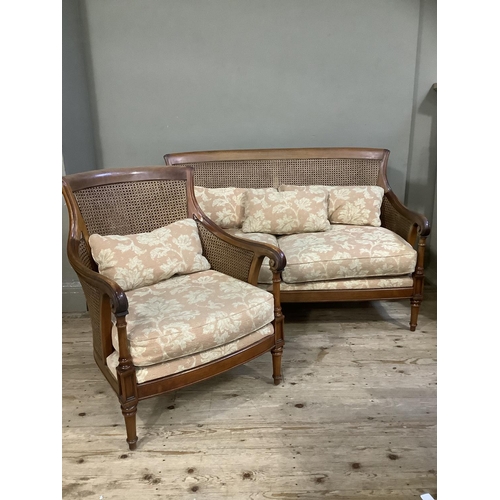 392 - A mahogany framed double begere caned two seater sofa and armchair, upholstered with loose cushions ... 