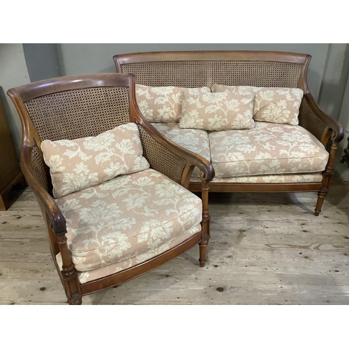 392 - A mahogany framed double begere caned two seater sofa and armchair, upholstered with loose cushions ... 