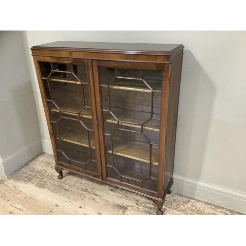 398 - A mid 20th century mahogany and glazed bookcase  having two tracery glazed doors and on short cabrio... 