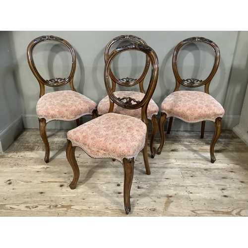 415 - A set of four Victorian mahogany balloon back chairs, foliate carved, upholstered serpentine seats a... 